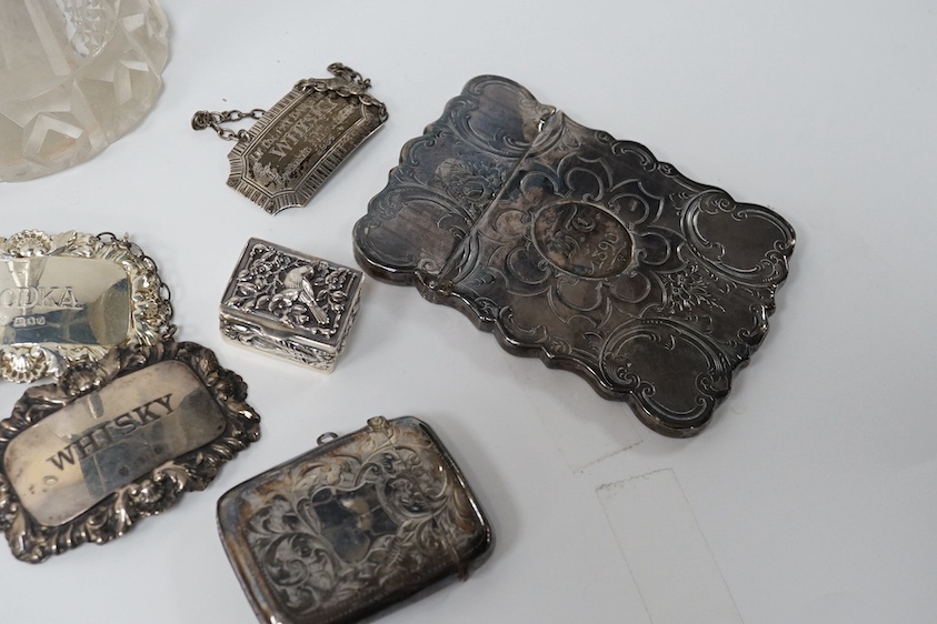 A small group of collectable silver including a Victorian engraved card case, Hilliard & Thomason, Birmingham, 1856, 10cm, three modern wine labels, a vesta case, a 925 pill box and an Edwardian mounted glass scent bottl